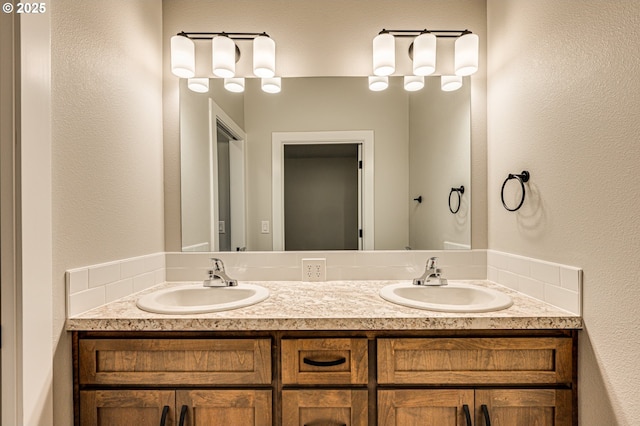 full bathroom featuring double vanity and a textured wall