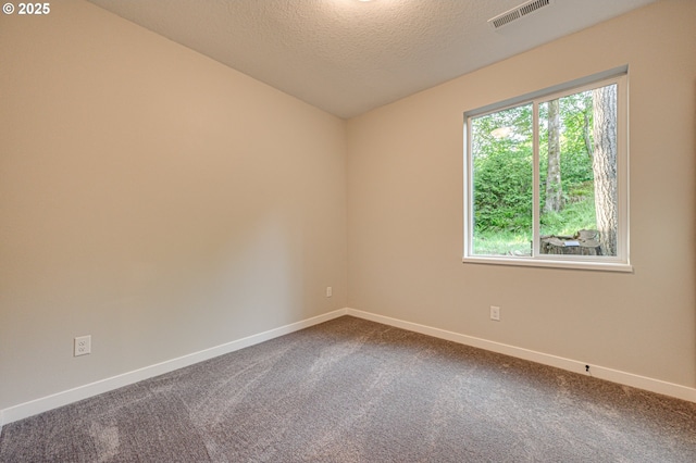 empty room with baseboards, dark carpet, a textured ceiling, and vaulted ceiling