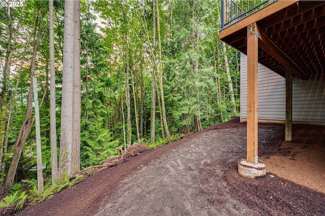 view of patio with a deck and a view of trees