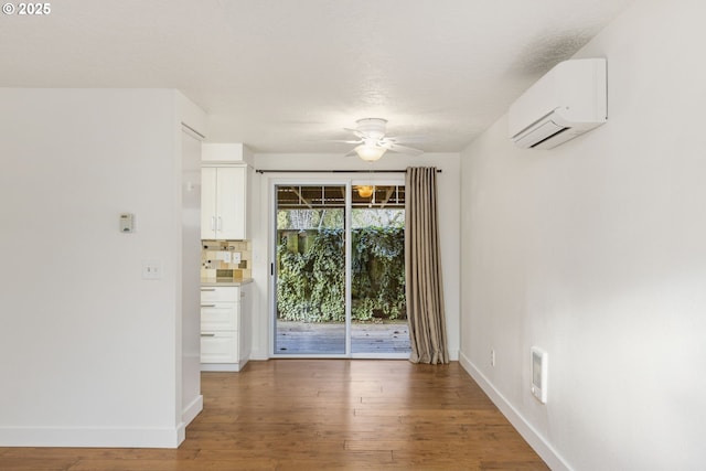 doorway to outside featuring ceiling fan, dark hardwood / wood-style flooring, and a wall mounted air conditioner