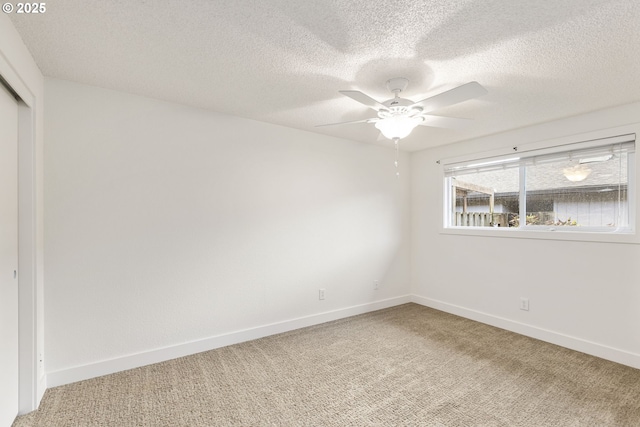 spare room featuring ceiling fan, carpet floors, and a textured ceiling