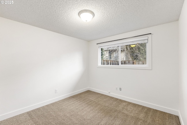 empty room with a textured ceiling and carpet flooring