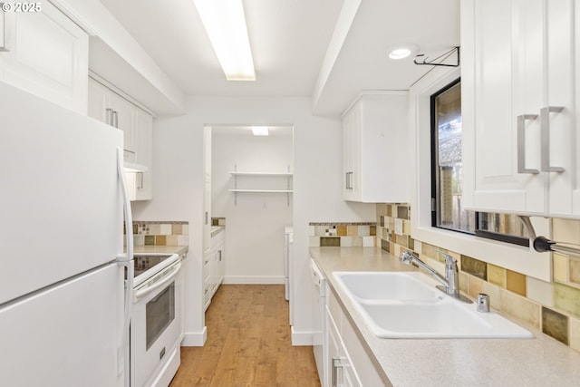 kitchen with sink, white appliances, white cabinetry, and tasteful backsplash