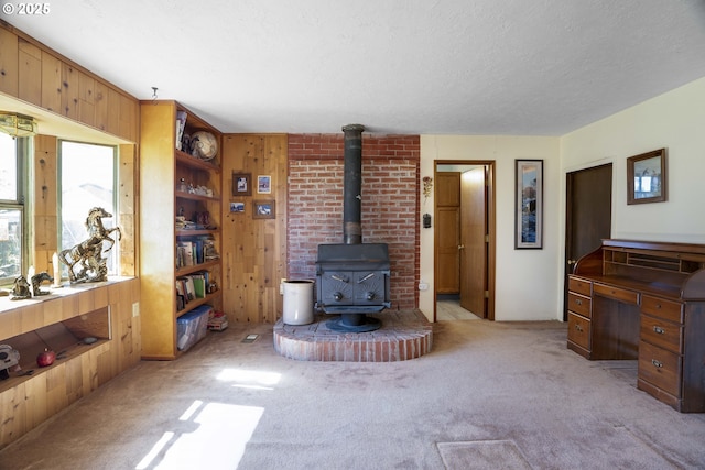 19587 NW Adcock Rd, Yamhill, OR 97148 - living area with a wood stove, wooden walls, light carpet, and a textured ceiling