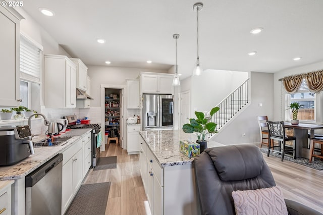7623 SE Roaring Ln, Hillsboro, OR 97123 - kitchen featuring appliances with stainless steel finishes, backsplash, white cabinets, recessed lighting, and decorative light fixtures