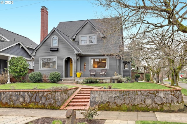 view of front of home with a chimney and a front yard