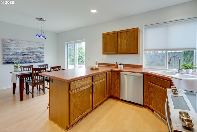 kitchen featuring range, light hardwood / wood-style flooring, stainless steel dishwasher, kitchen peninsula, and pendant lighting