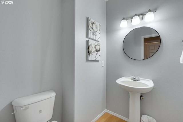 bathroom with hardwood / wood-style flooring and toilet