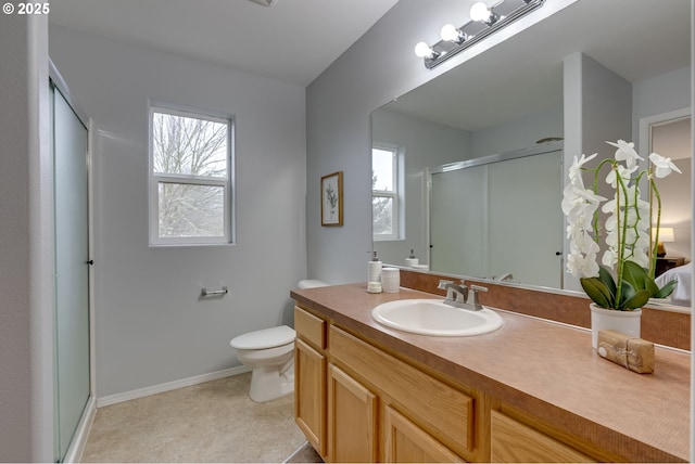 bathroom with vanity, toilet, and a shower with shower door