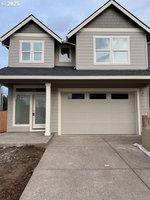 view of front of property featuring a garage, fence, and concrete driveway