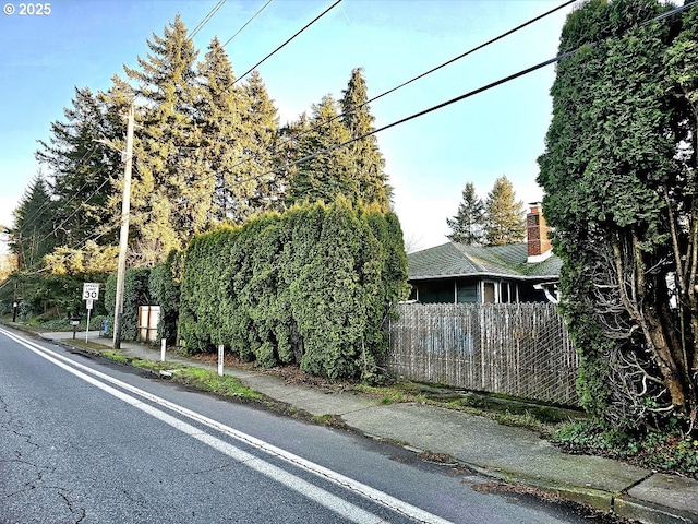 view of asphalt street with sidewalks and traffic signs