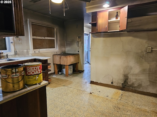kitchen with open shelves, a sink, light floors, and light countertops