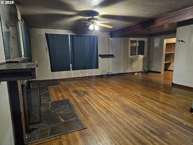 unfurnished living room with hardwood / wood-style floors, a ceiling fan, and a textured ceiling
