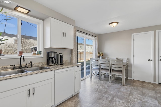 kitchen with white cabinetry, dishwasher, and sink