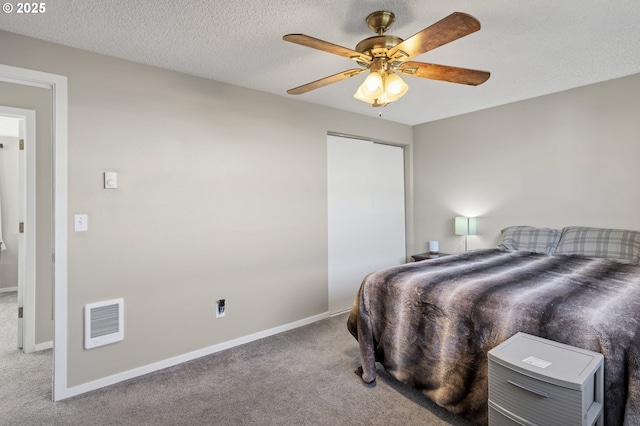 bedroom featuring ceiling fan, carpet floors, and a textured ceiling