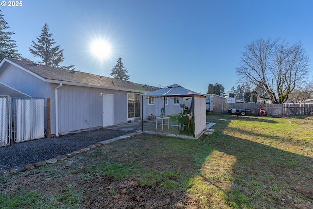 back of property with a yard and a gazebo