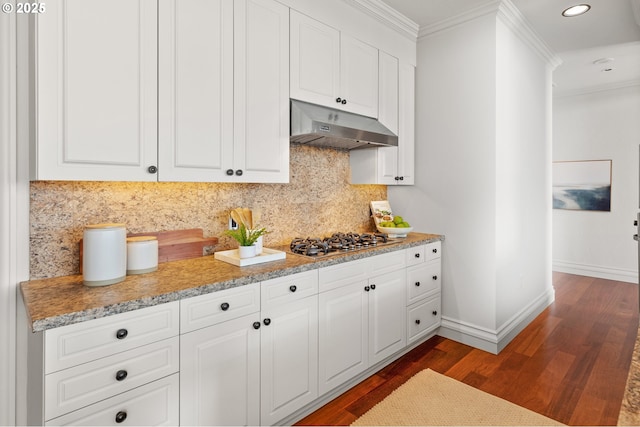kitchen with crown molding, baseboards, dark wood-style floors, stainless steel gas stovetop, and under cabinet range hood