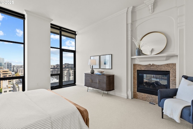 bedroom with carpet floors, a view of city, ornamental molding, floor to ceiling windows, and a multi sided fireplace