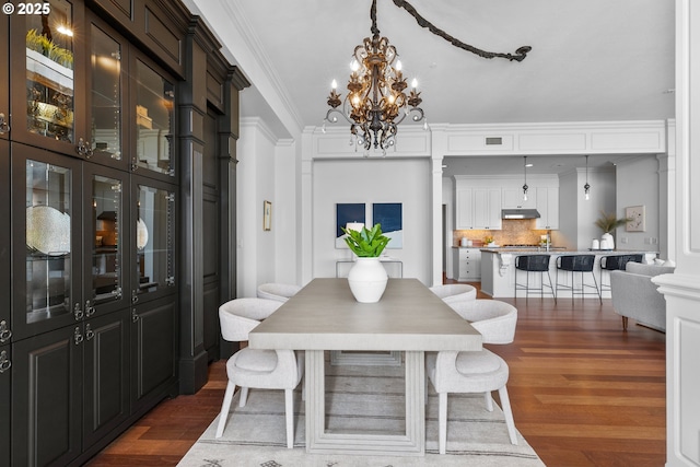 dining room with visible vents, ornamental molding, dark wood-style floors, and a chandelier