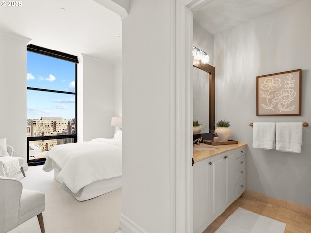 ensuite bathroom featuring connected bathroom, baseboards, floor to ceiling windows, and vanity