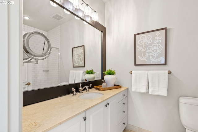 full bath with toilet, a tile shower, and vanity
