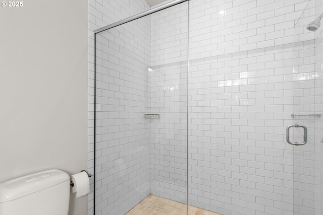 full bathroom featuring toilet and a shower stall