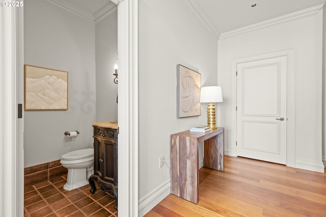 bathroom featuring crown molding, wood finished floors, baseboards, vanity, and toilet