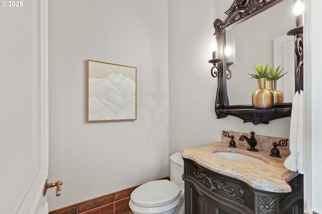 half bath featuring vanity and toilet