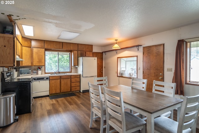 kitchen featuring decorative light fixtures, sink, dark hardwood / wood-style flooring, stainless steel appliances, and a textured ceiling