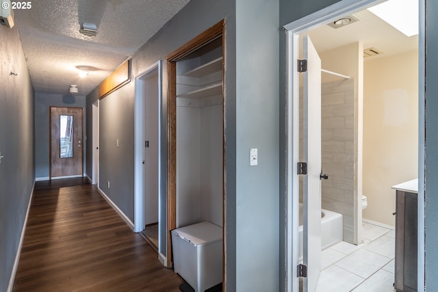 hallway featuring a textured ceiling and light wood-type flooring