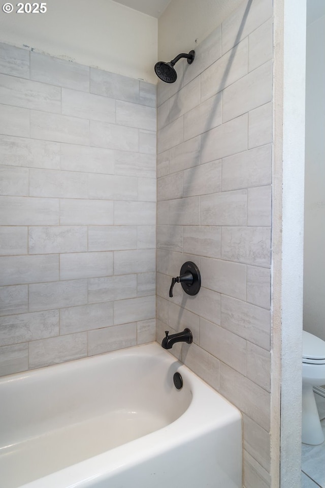 bathroom with tiled shower / bath and toilet