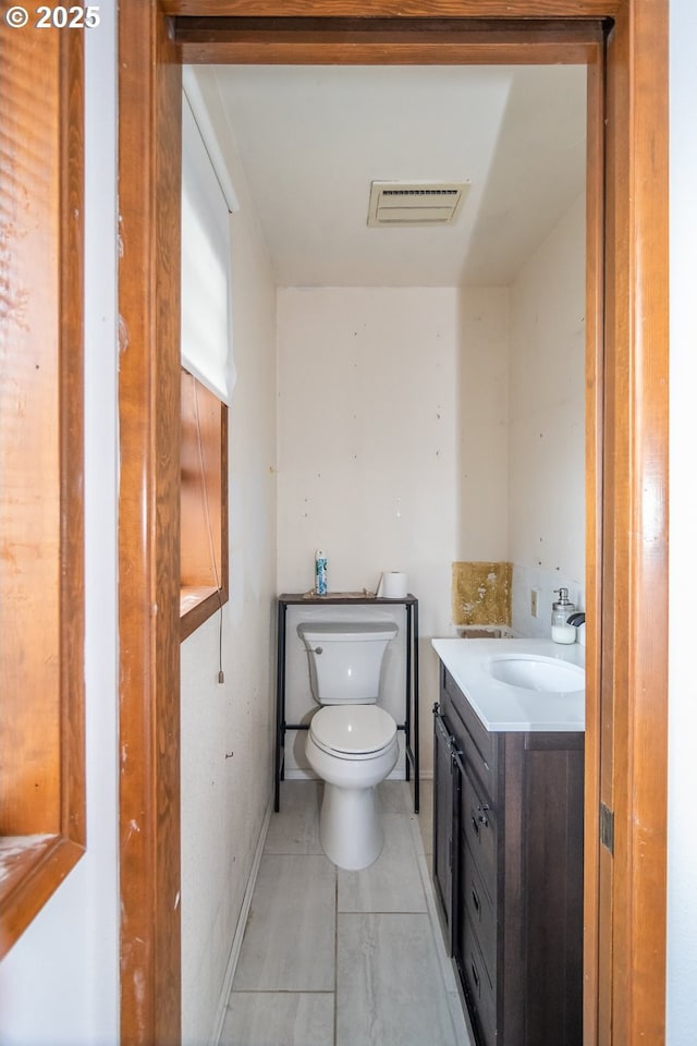 bathroom with tile patterned flooring, vanity, and toilet