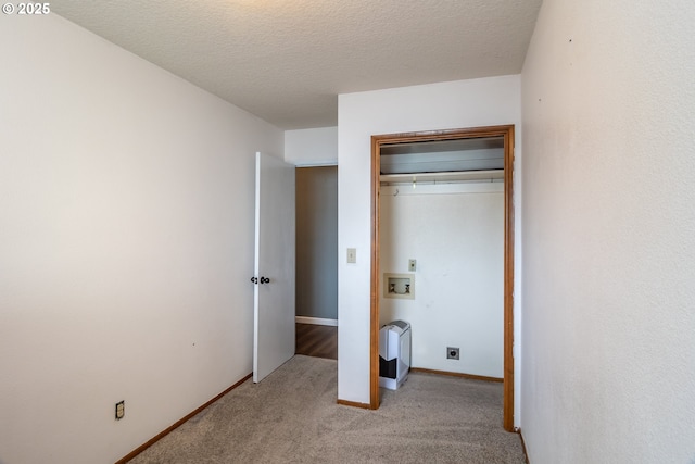 unfurnished bedroom featuring light carpet, a closet, and a textured ceiling