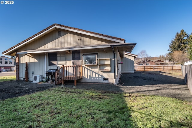 rear view of property with a yard and ac unit