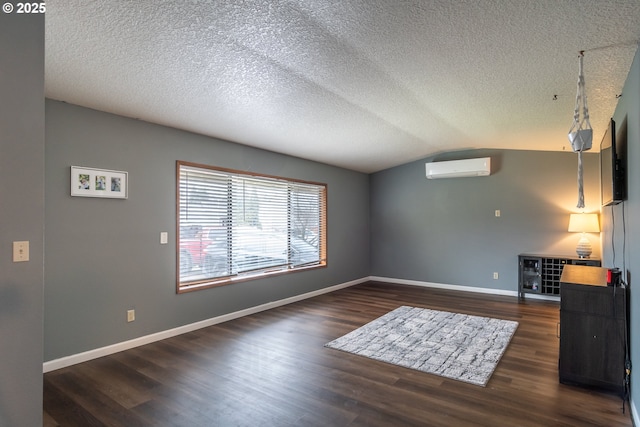 unfurnished living room featuring lofted ceiling, dark wood-type flooring, a wall mounted AC, and a textured ceiling