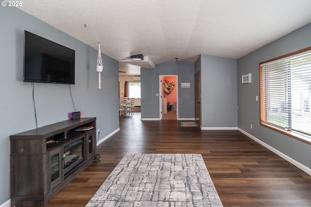 unfurnished living room featuring dark hardwood / wood-style flooring and a textured ceiling