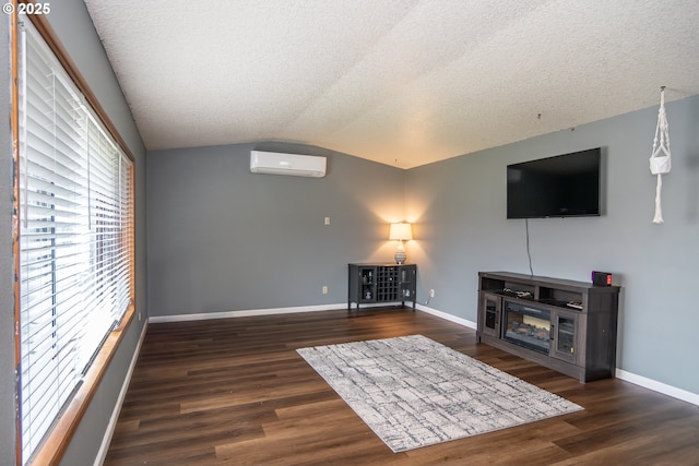 unfurnished living room with dark hardwood / wood-style flooring, a textured ceiling, vaulted ceiling, and a wall mounted AC