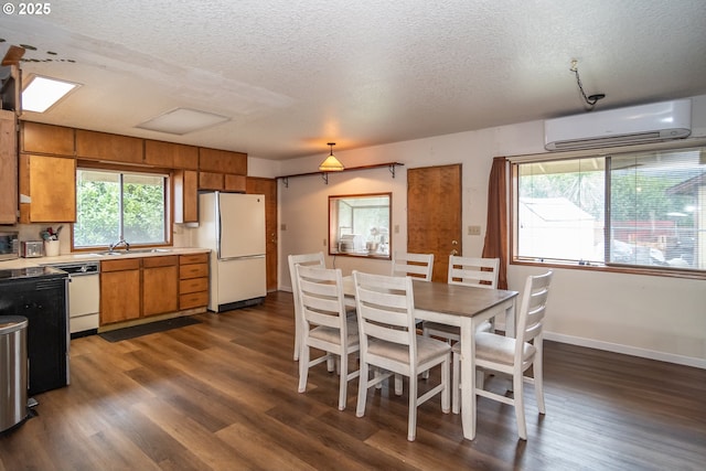 kitchen with an AC wall unit, dark wood-type flooring, a textured ceiling, and white appliances