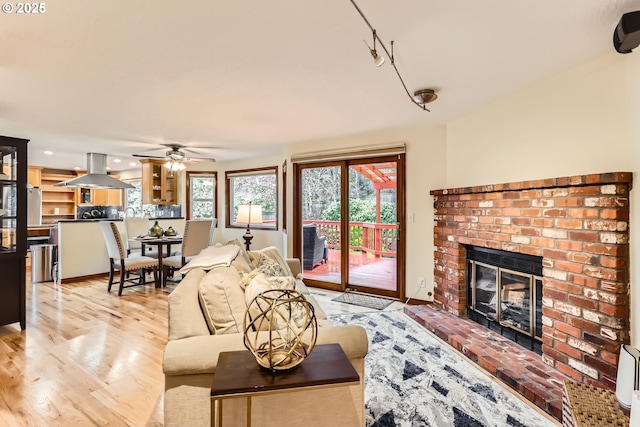 4939 Hampton Ct, Lake Oswego, OR 97035 - living area with a brick fireplace, a ceiling fan, light wood finished floors, and track lighting