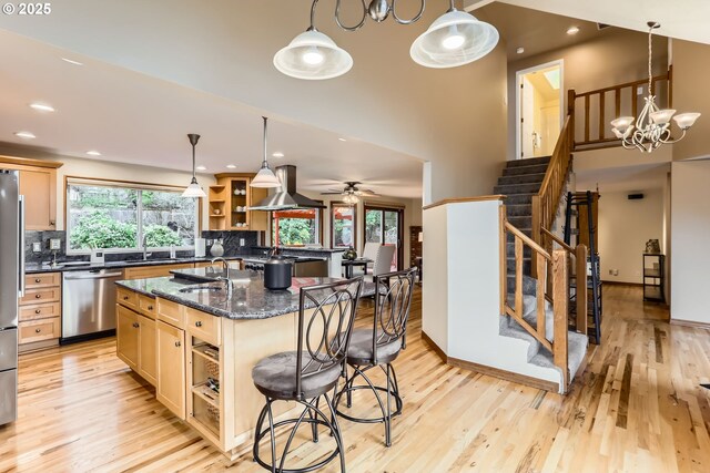 4939 Hampton Ct, Lake Oswego, OR 97035 - kitchen with appliances with stainless steel finishes, island range hood, open shelves, a kitchen breakfast bar, and light wood-style floors