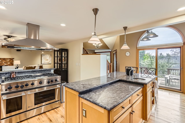 4939 Hampton Ct, Lake Oswego, OR 97035 - kitchen with range with two ovens, island range hood, a sink, light wood-style flooring, and dark stone countertops