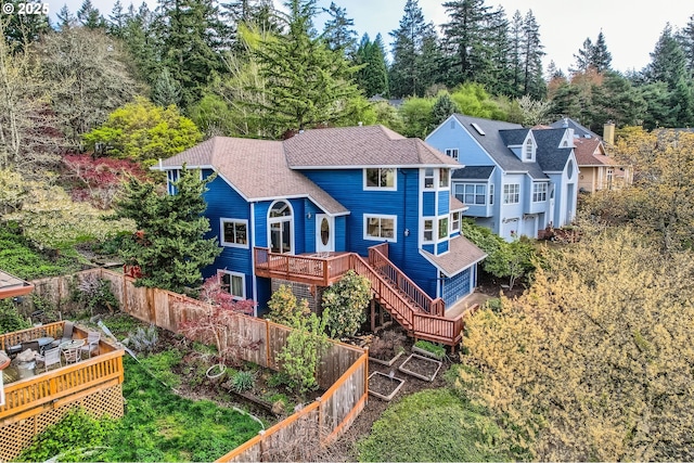 4939 Hampton Ct, Lake Oswego, OR 97035 - back of property with a deck, view of wooded area, and roof with shingles