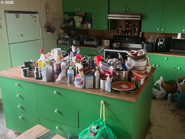 kitchen with green cabinets, range with electric cooktop, white fridge, and ventilation hood