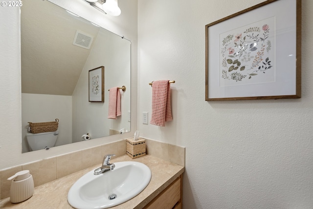 18246 SW Orlov Ct, Beaverton, OR 97078 - bathroom featuring vanity, toilet, lofted ceiling, and backsplash