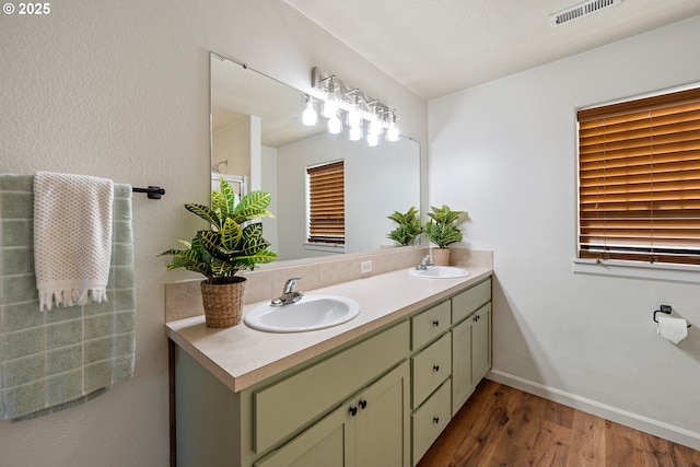 18246 SW Orlov Ct, Beaverton, OR 97078 - bathroom featuring double vanity, wood finished floors, and baseboards