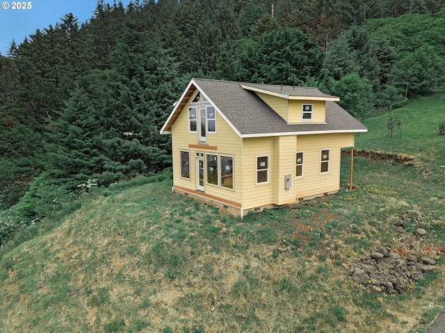 227 Windsong St, Yachats, OR 97498 - view of property exterior with a forest view, a shingled roof, crawl space, and a yard