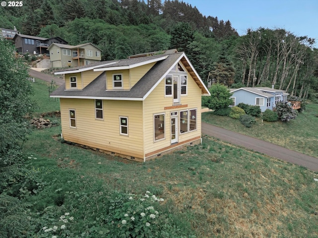 227 Windsong St, Yachats, OR 97498 - back of house featuring crawl space, roof with shingles, a yard, and a view of trees