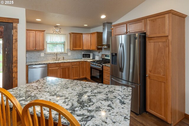 145343 Birchwood Dr, La Pine, OR 97739 - kitchen with stainless steel appliances, wall chimney exhaust hood, a sink, dark wood-style flooring, and decorative backsplash