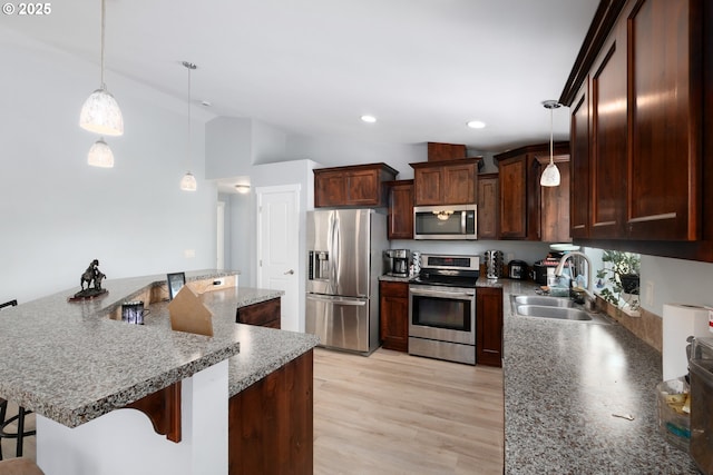 5615 Macleay Rd, Salem, OR 97317 - kitchen featuring stainless steel appliances, a sink, vaulted ceiling, a breakfast bar area, and light wood-style flooring