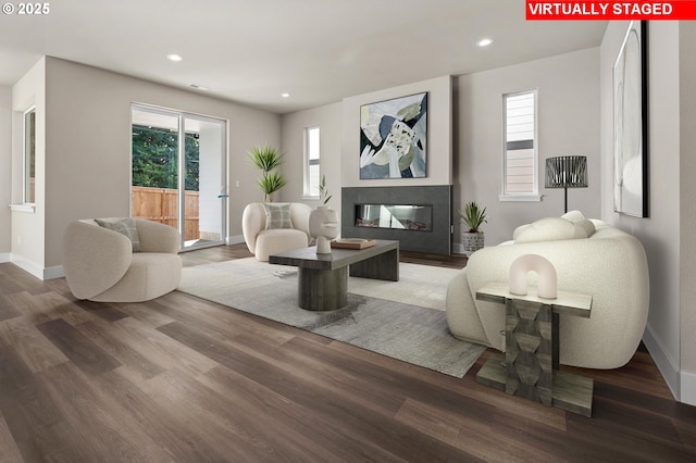 living room featuring a multi sided fireplace and wood-type flooring